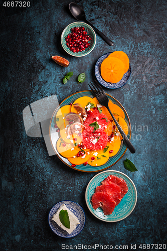 Image of Persimmon carpaccio salad with pomegranate, feta cheese, pink grapefruit and figs