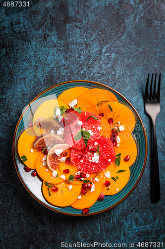 Image of Persimmon carpaccio salad with pomegranate, feta cheese, pink grapefruit and figs