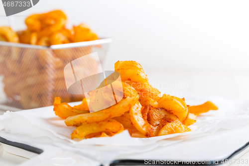 Image of Spicy seasoned curly fries. Ready to eat.