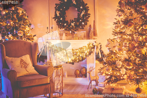 Image of Beautiful Christmas interior decoration for family celebration with pine tree, armchair, fireplace