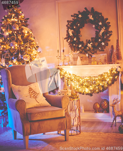 Image of Christmas interior concept. With fireplace, armchair, pine tree, wrapped gifts, lights