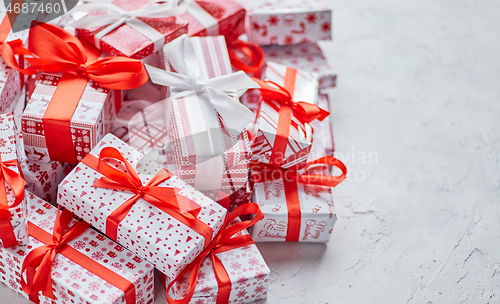 Image of Various pattern and size Christmas boxes placed on white background. Wrapped in festive paper