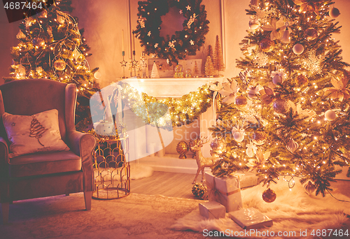 Image of Christmas interior concept. With fireplace, armchair, pine tree, wrapped gifts, lights