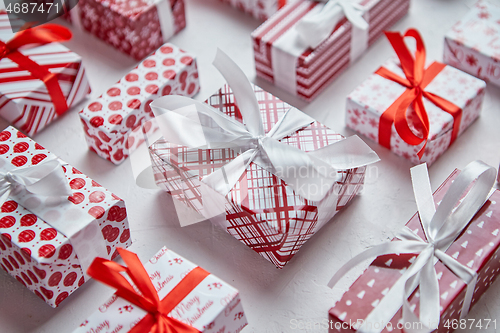 Image of Colorful white and red Christmas theme. Wrapped gifts in festive paper with ribbon