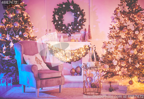 Image of Christmas interior concept. With fireplace, armchair, pine tree, wrapped gifts, lights