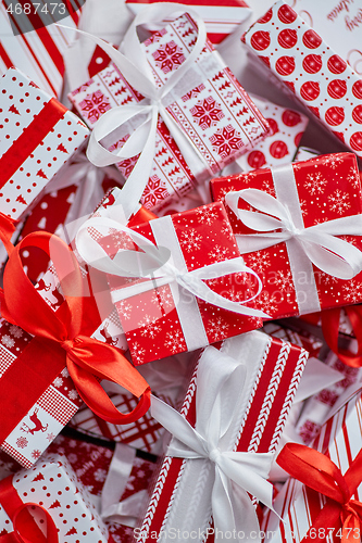 Image of Various pattern and size Christmas boxes placed on white background. Wrapped in festive paper