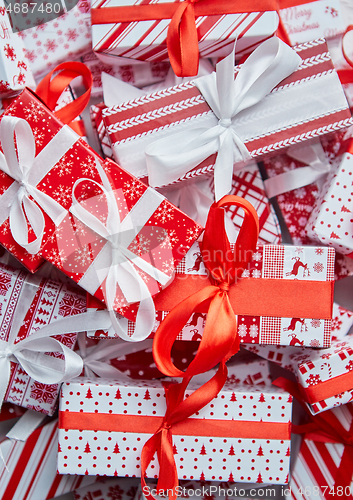 Image of A pile various size wrapped in festive paper boxed gifts placed on stack. Christmas concept