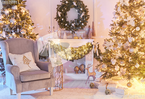 Image of Christmas interior concept. With fireplace, armchair, pine tree, wrapped gifts, lights