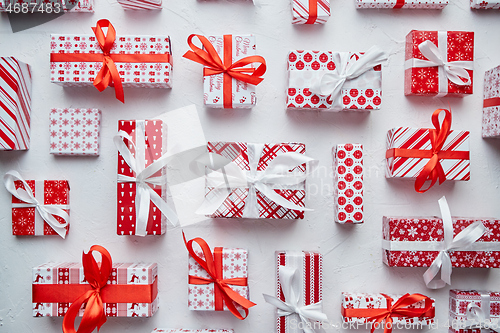 Image of Various pattern and size Christmas boxes placed on white background. Wrapped in festive paper