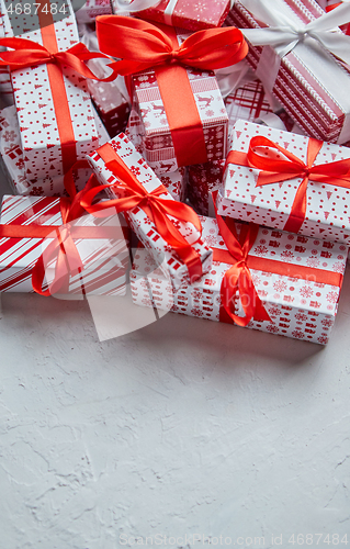 Image of A pile various size wrapped in festive paper boxed gifts placed on stack. Christmas concept