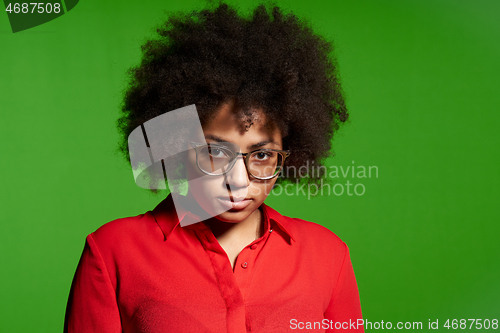 Image of Discontent serious young African-American girl in glasses and red shirt