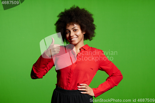 Image of Smiling young African-American girl looking at camera gesturing thumb up