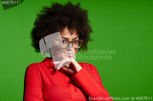 Image of Smiling young African-American girl in glasses and red shirt looking at camera