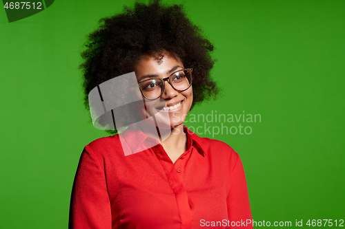 Image of Smiling young African-American girl in glasses and red shirt looking at camera