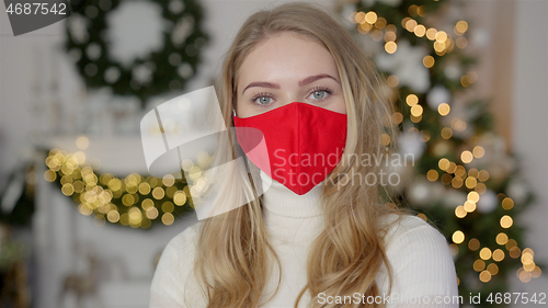 Image of Portrait of a beautiful woman. Woman wears the protective mask from the virus. Pandemic Christmas