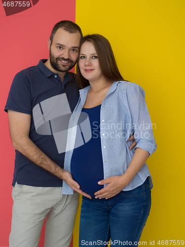 Image of pregnant couple  isolated over colorful background