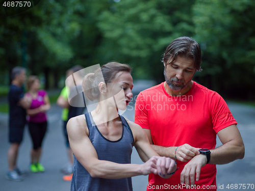 Image of sporty couple using smart watches