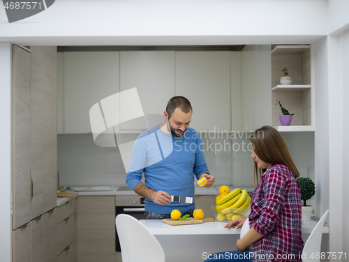 Image of couple cooking food fruit lemon juice at kitchen