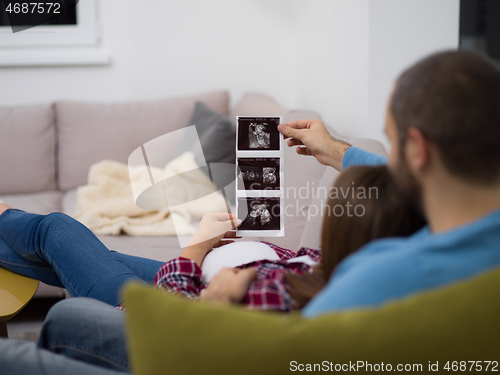 Image of pregnant couple looking baby\'s ultrasound