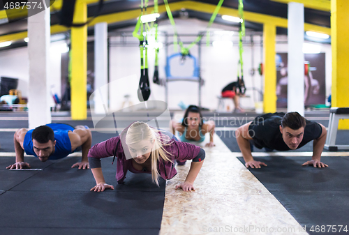 Image of young healthy people doing pushups