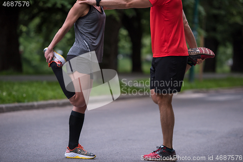 Image of runners team warming up and stretching before morning training