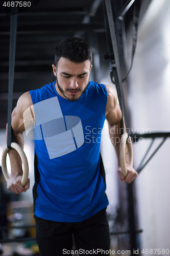 Image of man working out pull ups with gymnastic rings