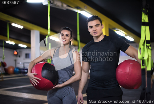 Image of young athletes couple working out with medical ball