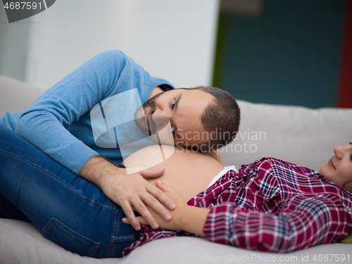 Image of future dad listening the belly of his pregnant wife