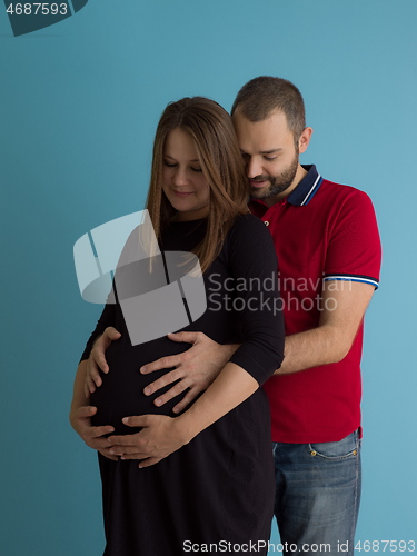 Image of pregnant couple  isolated over blue background