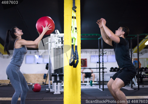 Image of young athletes couple working out with medical ball