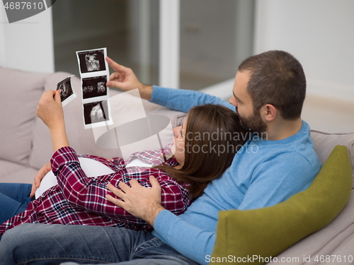 Image of pregnant couple looking baby\'s ultrasound