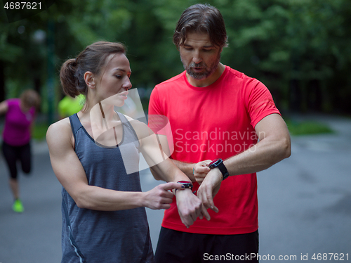 Image of sporty couple using smart watches