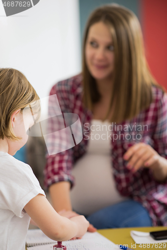 Image of daughter painting nails to her pregnant mom