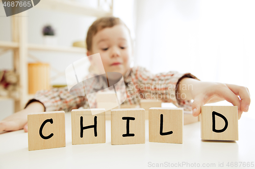 Image of Wooden cubes with word CHILD in hands of little boy