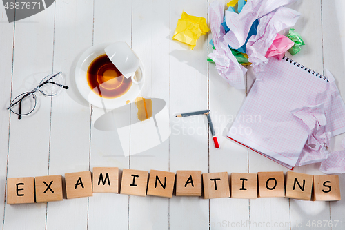 Image of Stationery and word EXAMINATIONS made of letters on wooden background