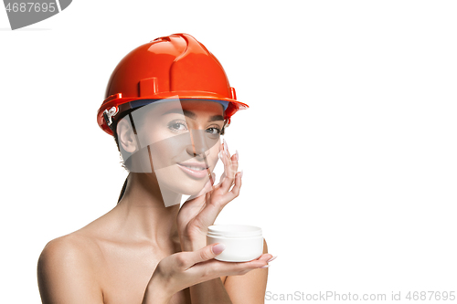 Image of Portrait of confident female worker in orange helmet