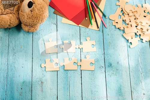 Image of Concept of mock up and pieces of puzzles on the background of wooden table