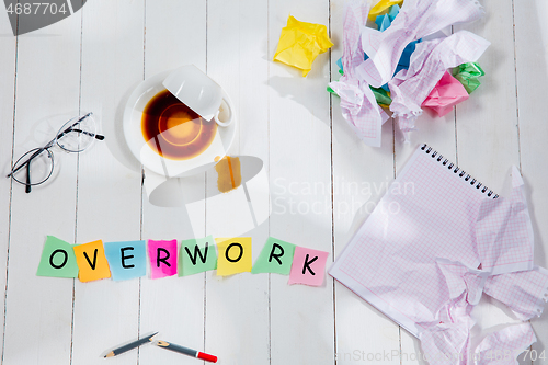 Image of OVERWORK. Message in wooden cubes on a desk background.