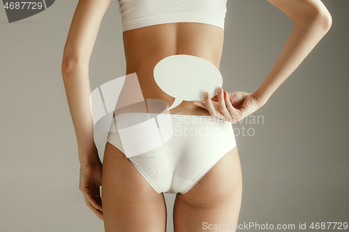 Image of Young adult woman holding empty paper card for sign or symbol.