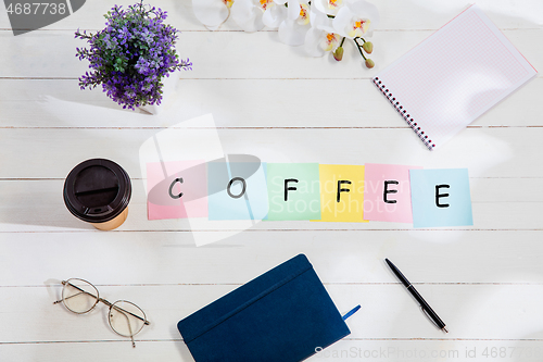 Image of COFFEE. Message at colorful note papers on a desk background.