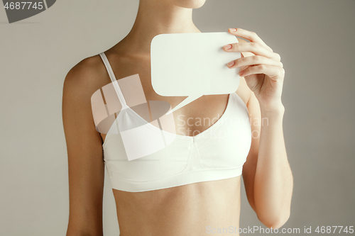 Image of Young adult woman holding empty paper card for sign or symbol.