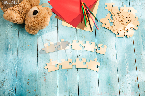 Image of Concept of mock up and pieces of puzzles on the background of wooden table