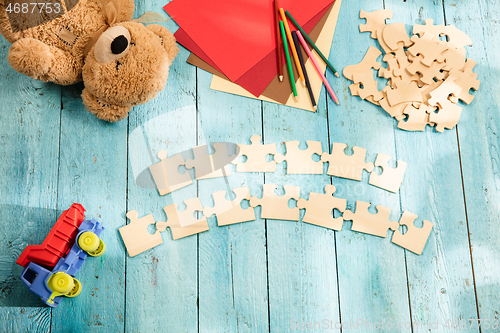 Image of Concept of mock up and pieces of puzzles on the background of wooden table