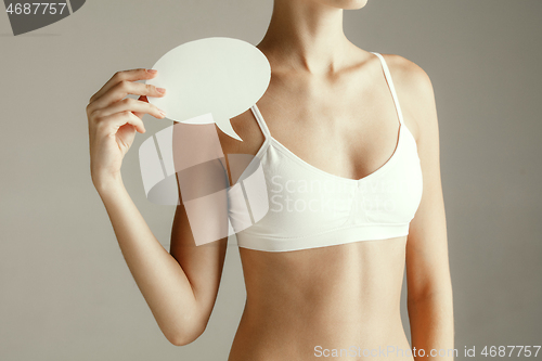 Image of Young adult woman holding empty paper card for sign or symbol.