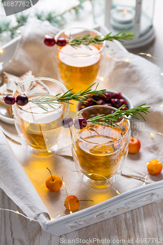 Image of Christmas apple cider cocktail with cranberries and rosemary