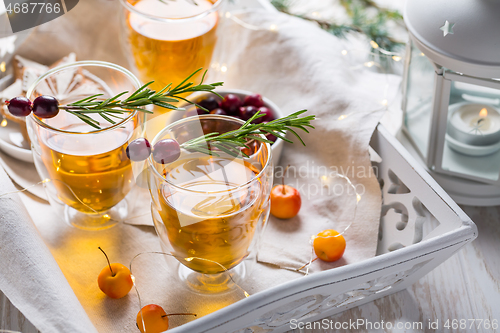 Image of Christmas apple cider cocktail with cranberries and rosemary