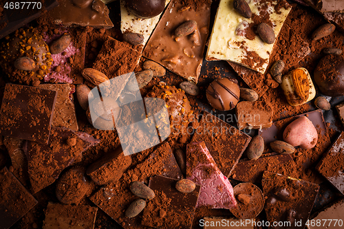 Image of Variation of chocolate and candy with cocoa and cocoa beans as background