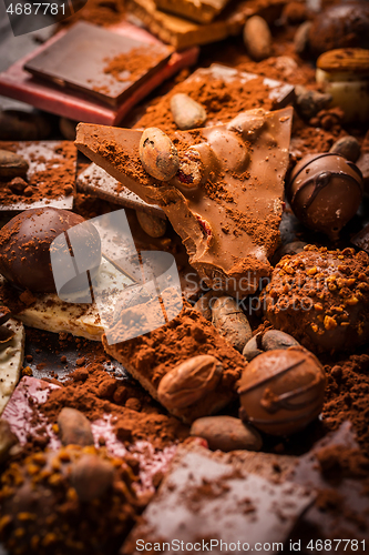 Image of Variation of chocolate and candy with cocoa and cocoa beans as background