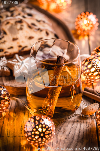 Image of Apple mulled wine with Christmas Stollen. Traditional Sweet Fruit Loaf with icing sugar.  