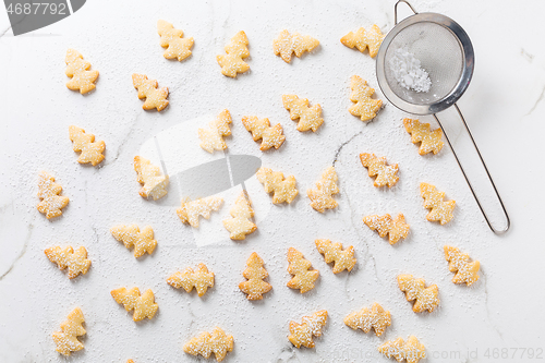 Image of Homemade Christmas cookies in Christmas tree shape on marble background